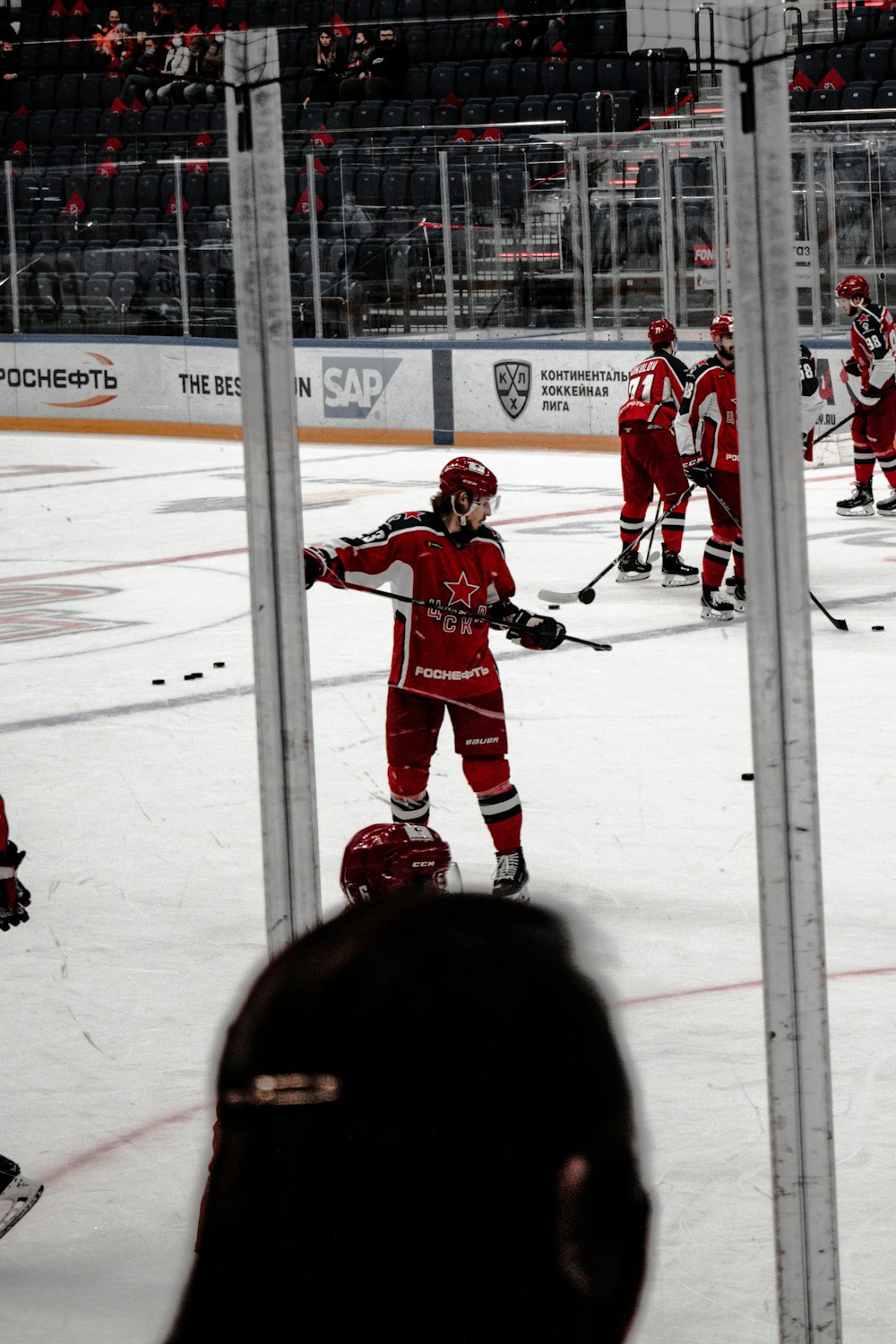 man in red ice hockey jersey playing hockey