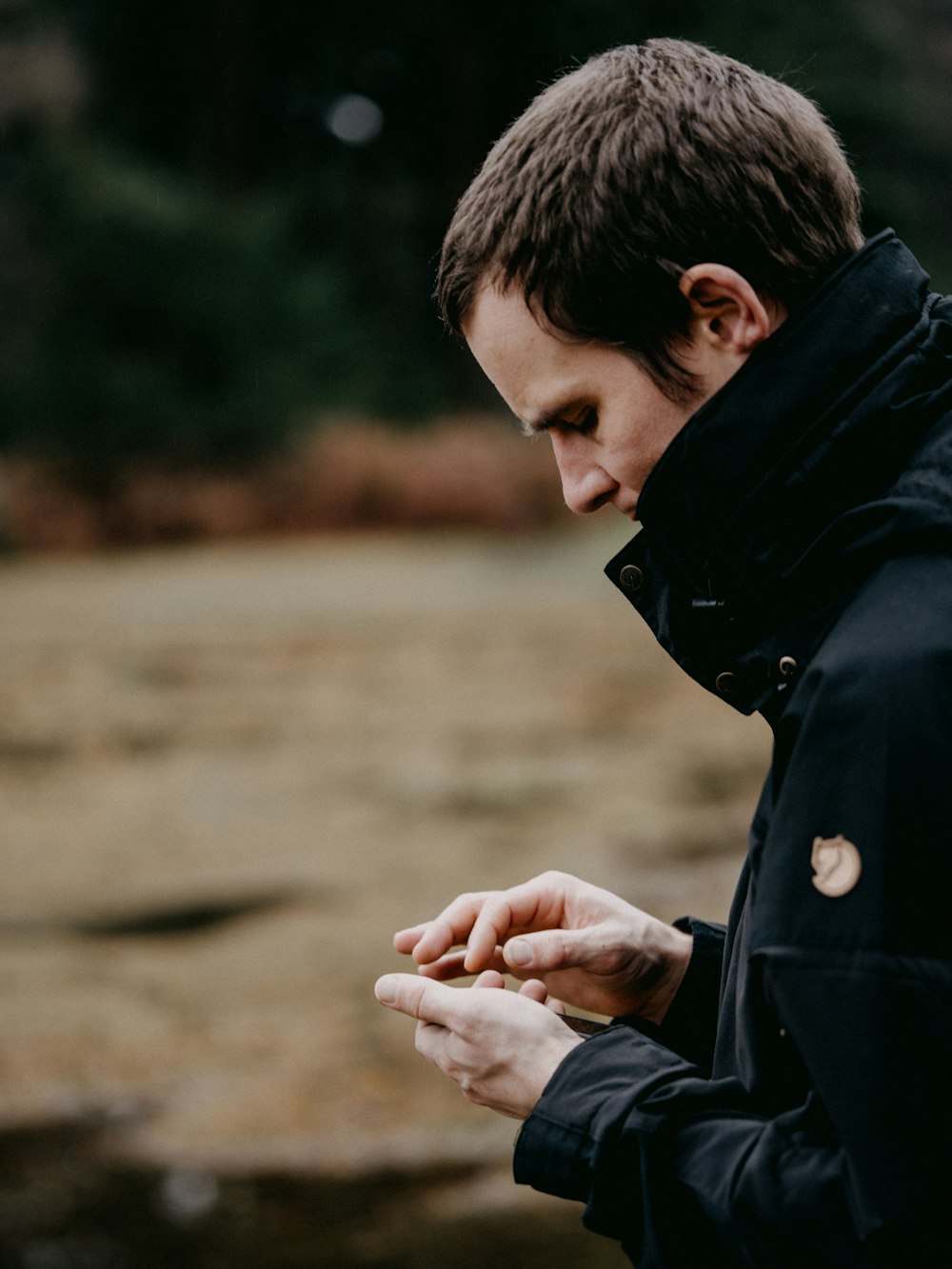 man in black jacket holding smartphone