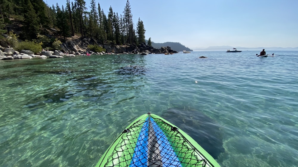 green and blue hammock on green body of water during daytime