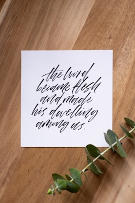 A delicate RSVP card with handwritten notes and eucalyptus leaves on a textured surface.