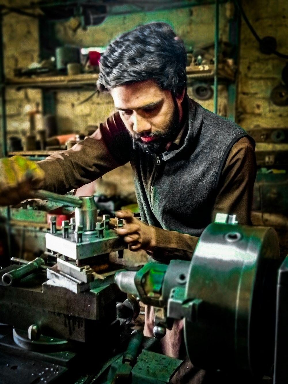 man in black leather jacket holding green and black power tool