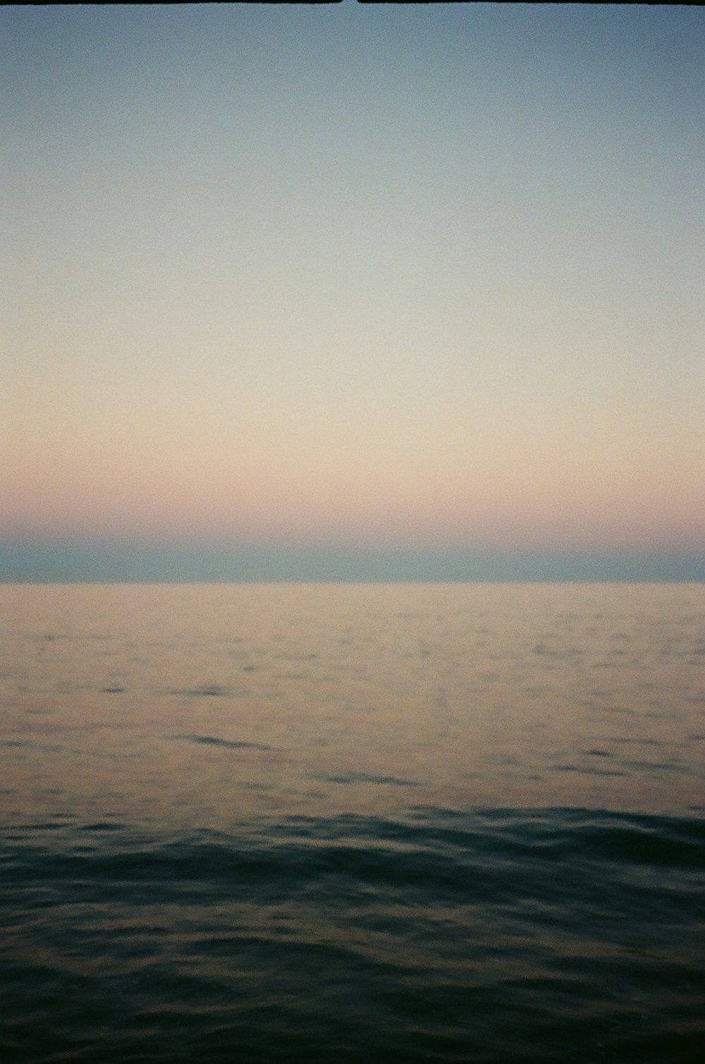 body of water under white sky during daytime