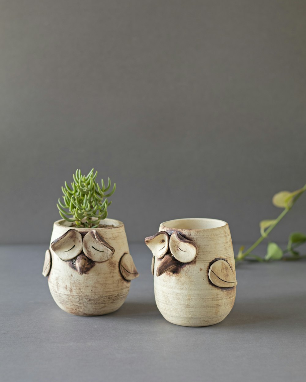 2 white ceramic mugs on gray table