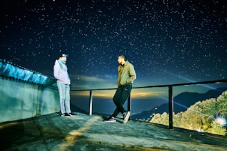 A couple watching stars together on a quiet rooftop.