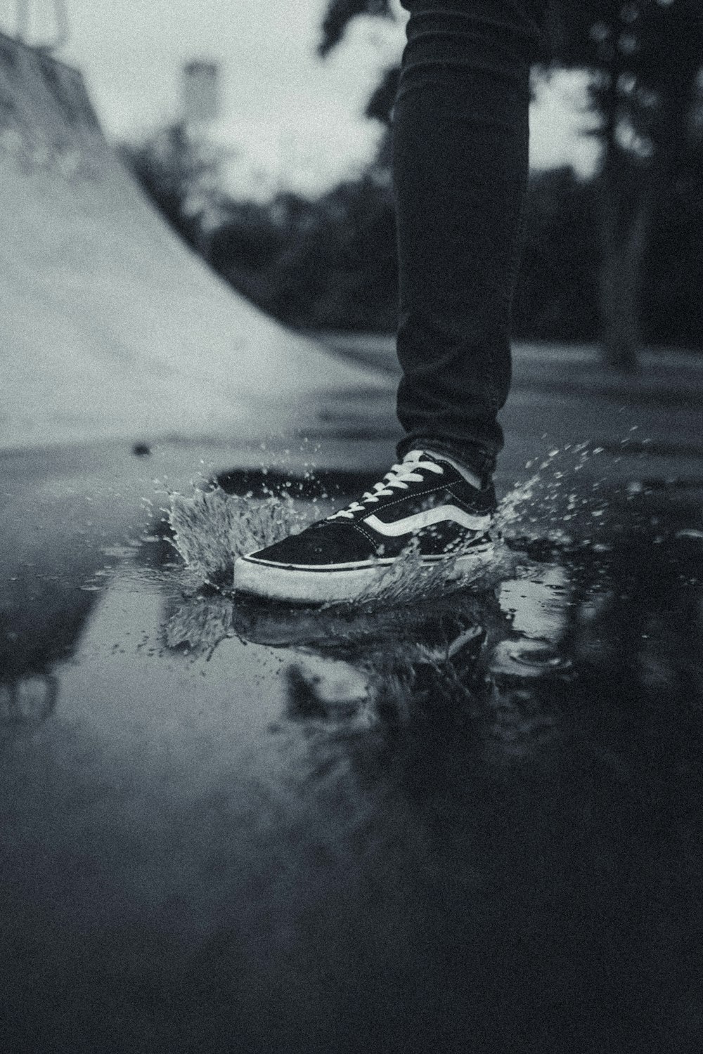 person in black pants wearing black and white sneakers