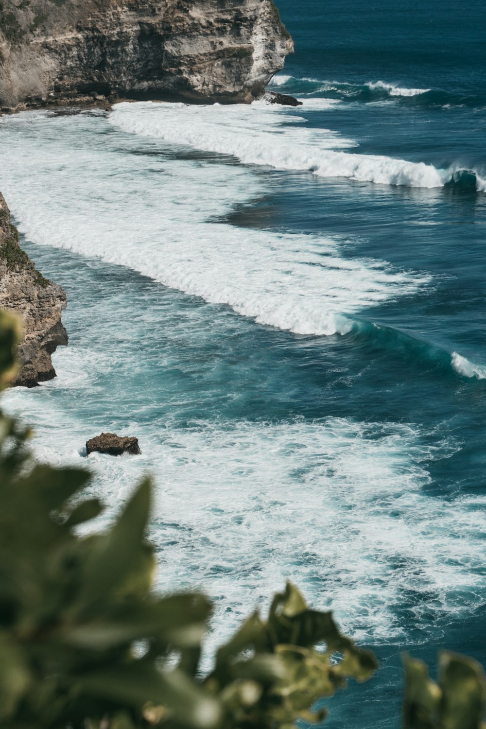 ocean waves crashing on rocky shore during daytime