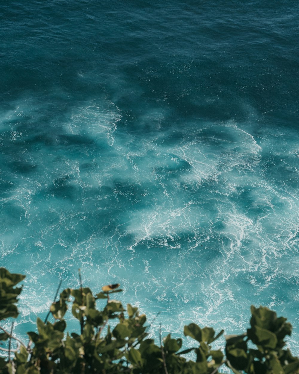 green and brown rocks on blue sea water during daytime