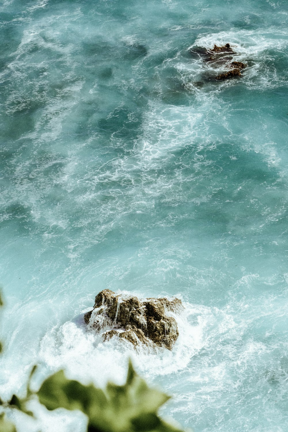 brown rock formation on body of water during daytime