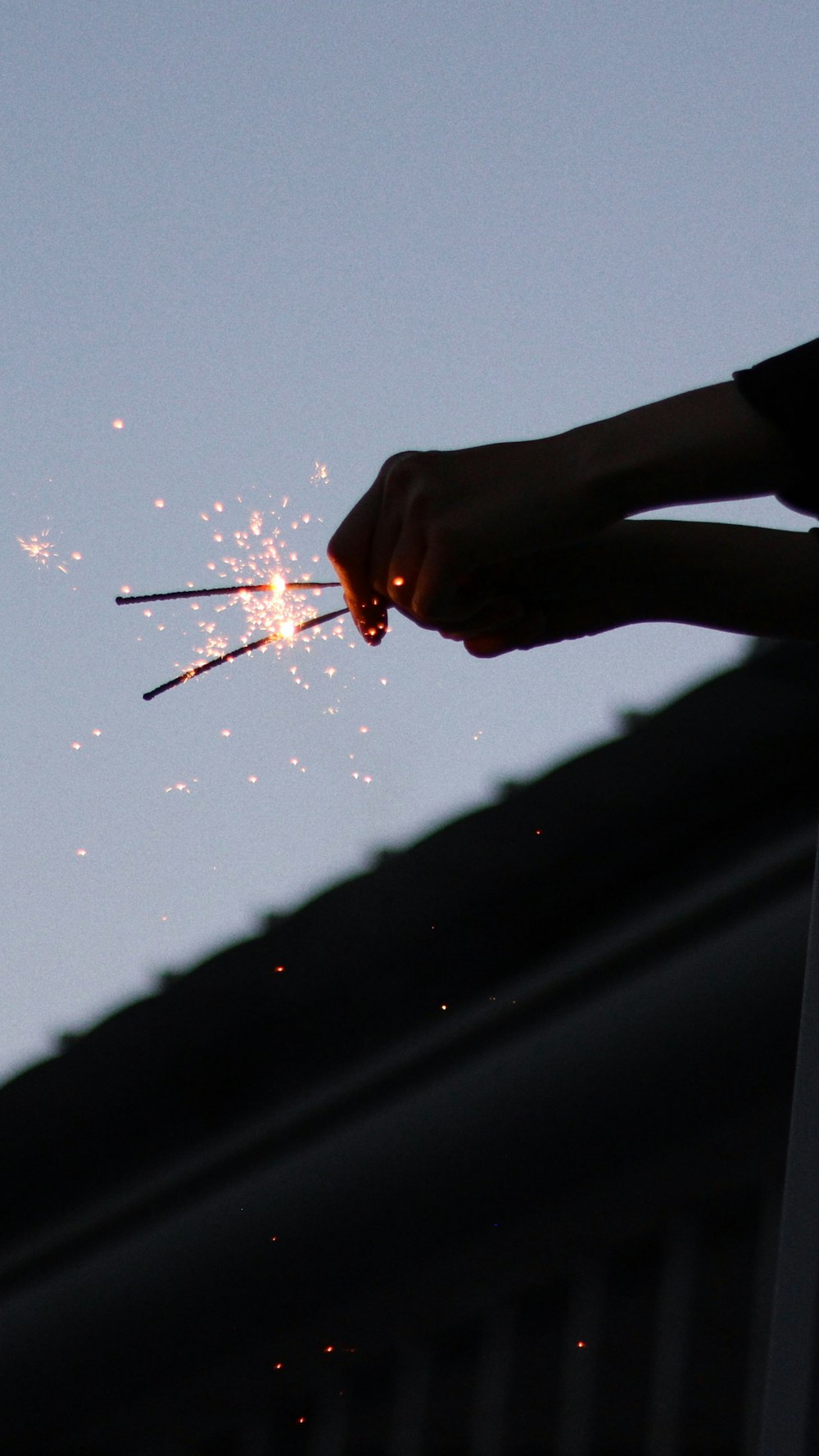 person holding lighted sparkler during night time