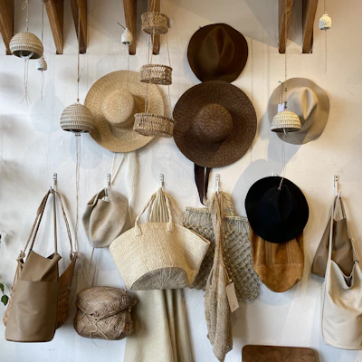 A stylish collection of hats, scarves, and bags displayed on rustic hooks and tables.