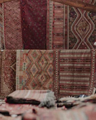 Sunlight filtering through a window onto a collection of vintage rugs rolled and stacked neatly.