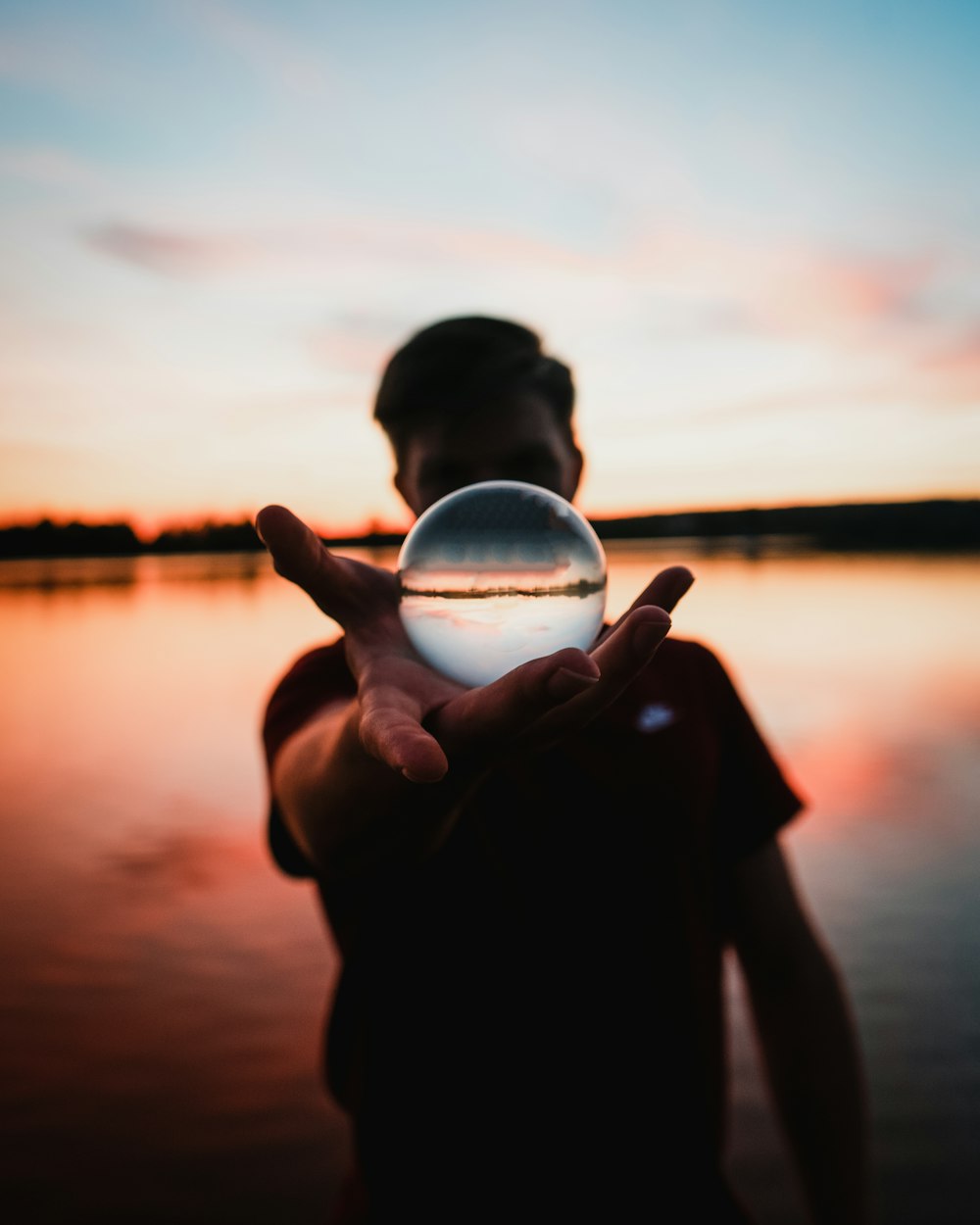 man holding clear glass ball