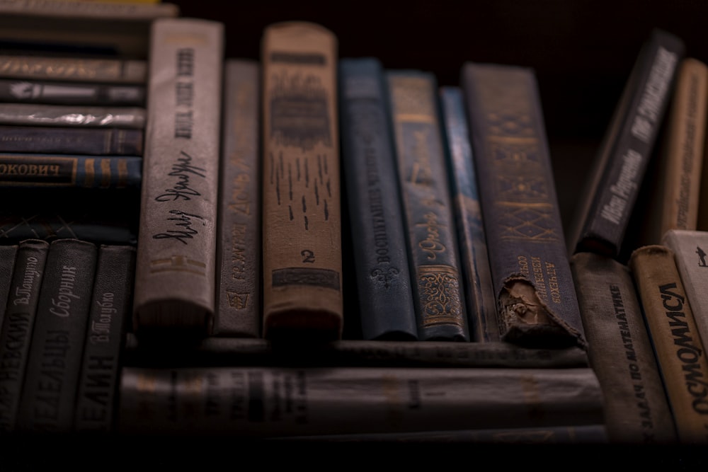 brown and black books on black wooden shelf