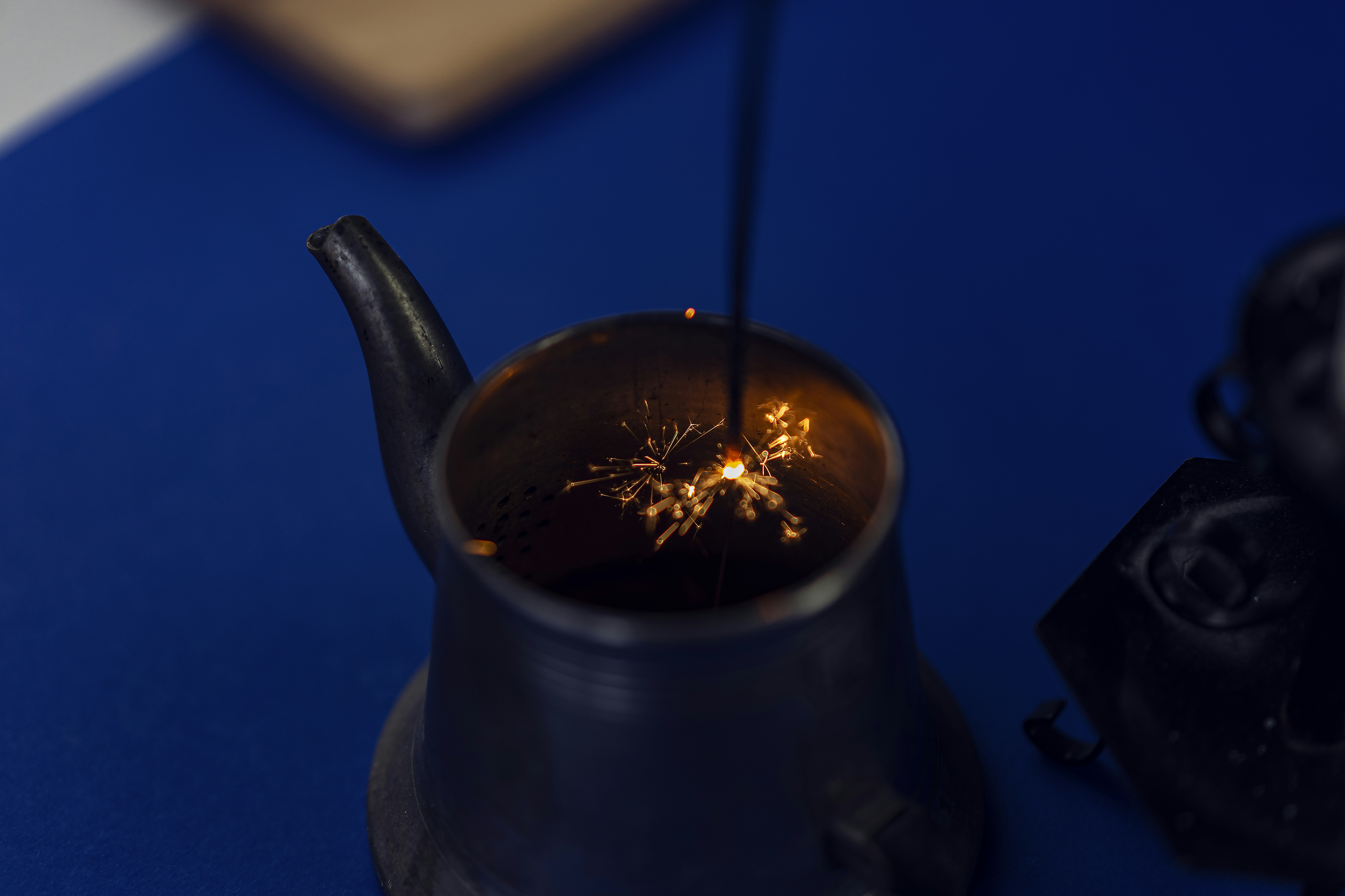 black ceramic teapot with fire