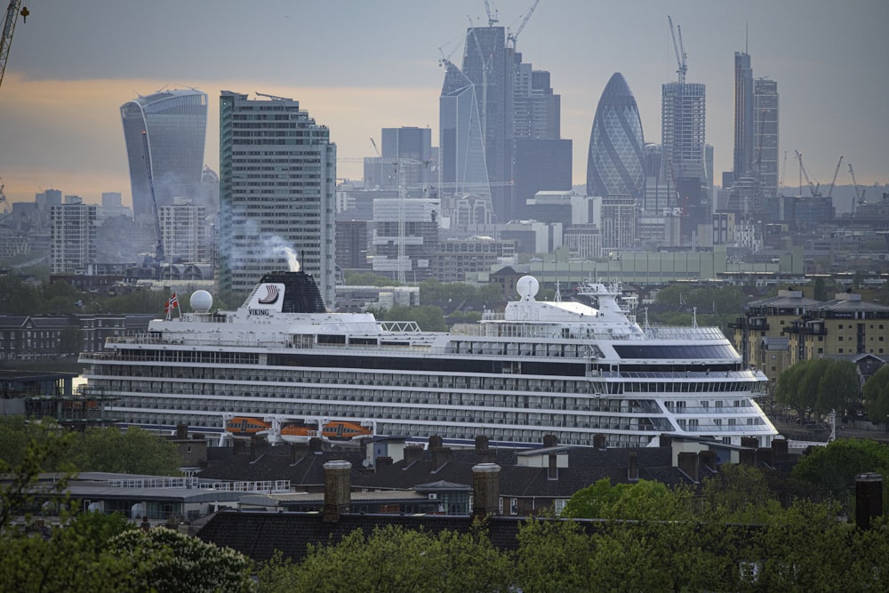 white and black cruise ship on sea near city buildings during daytime