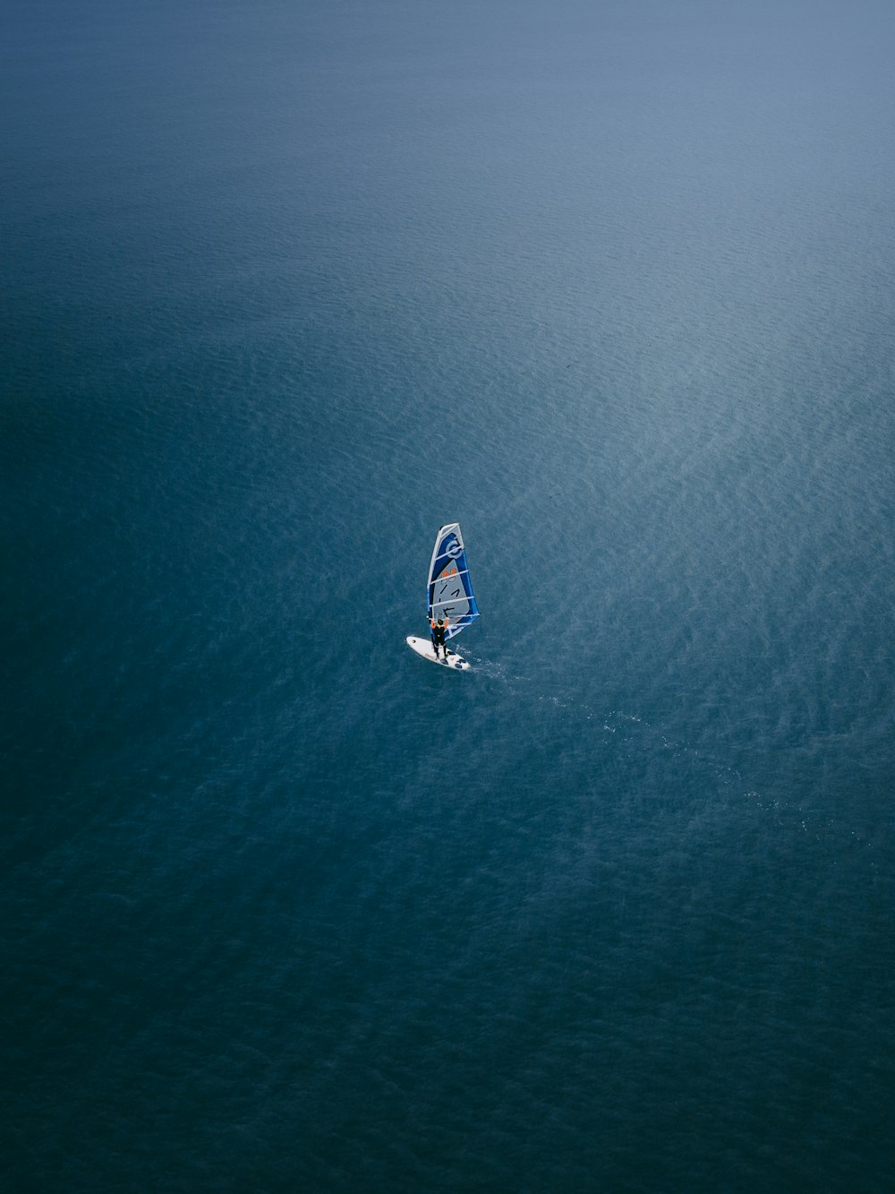 aerial view of white and blue boat on sea during daytime