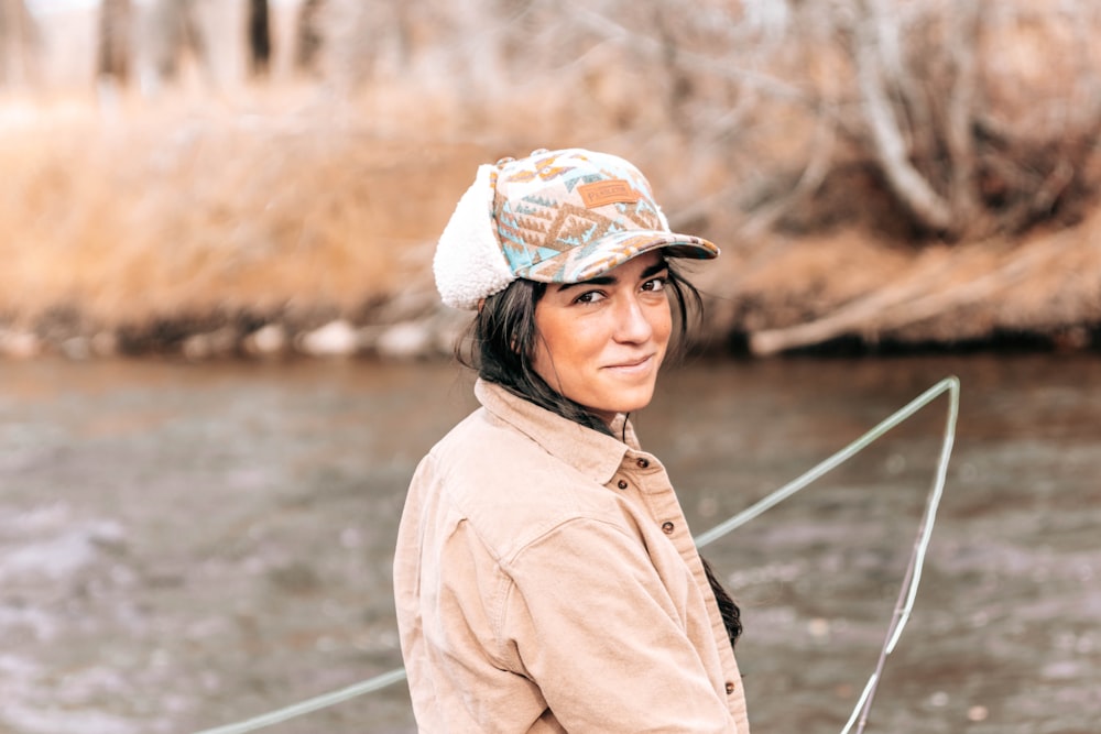 woman in brown coat wearing white and blue cap