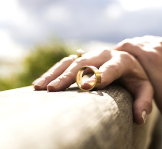 person holding gold wedding band