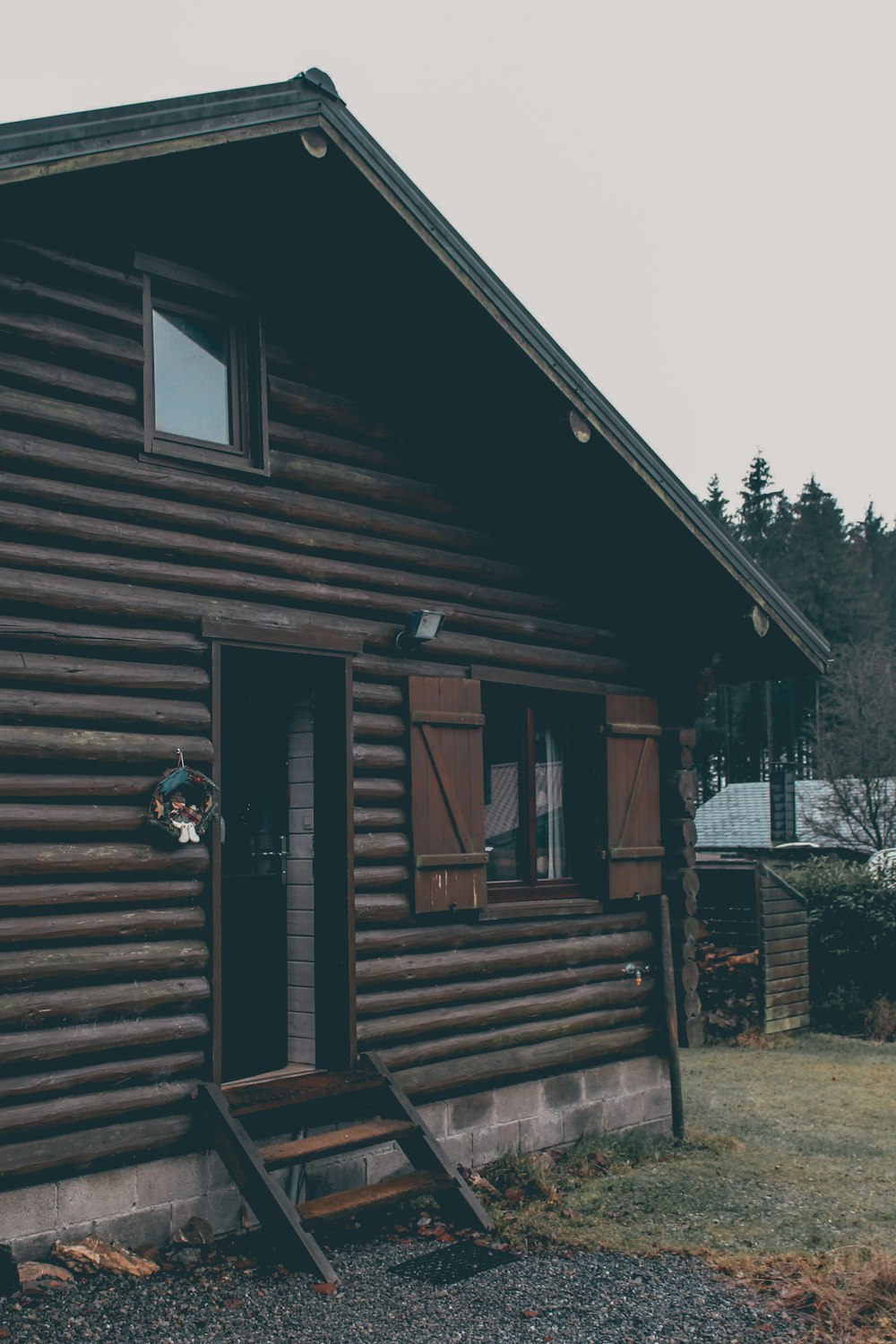 brown wooden house near green trees during daytime