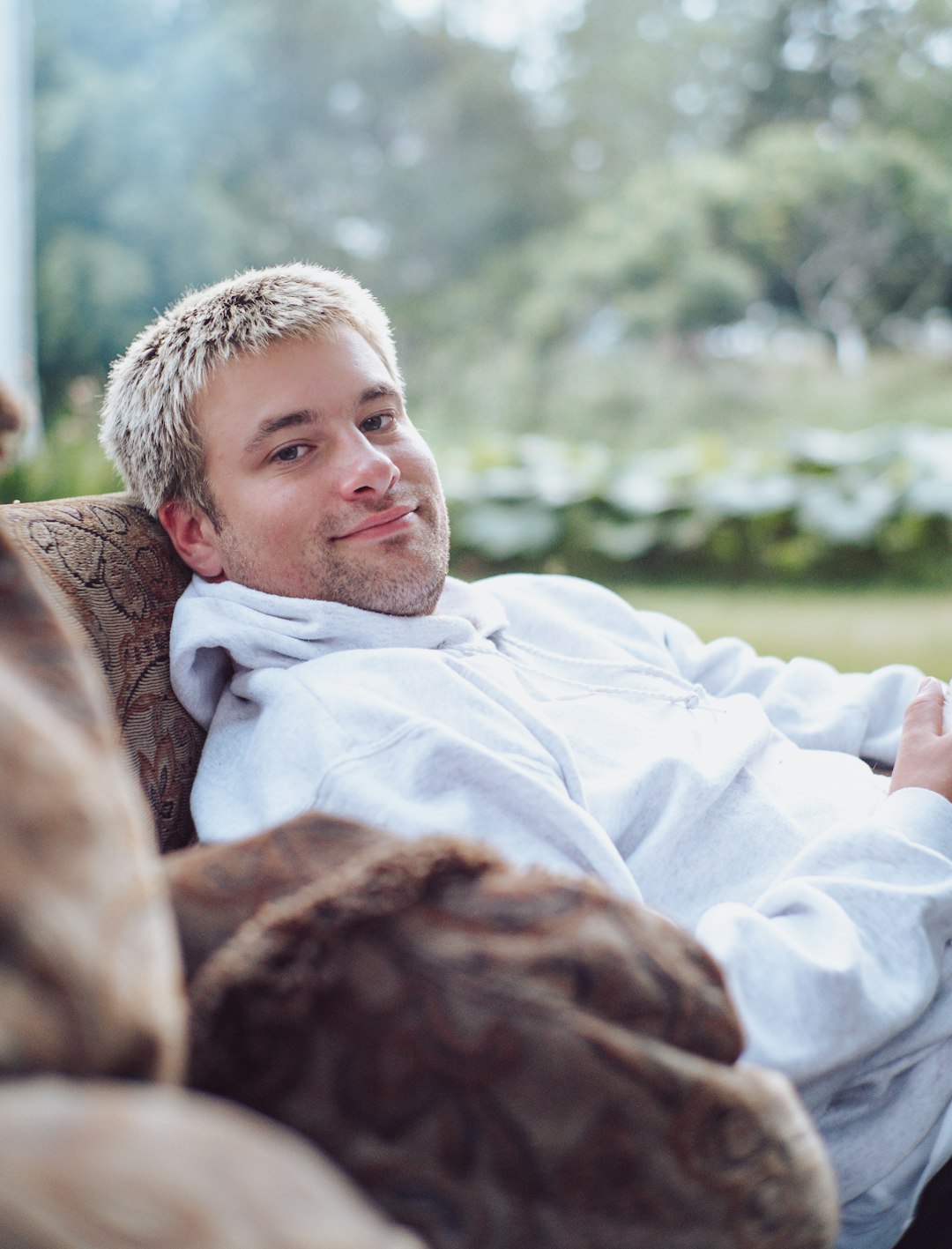 man in white dress shirt lying on brown textile