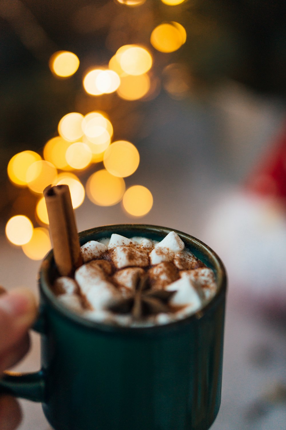 personne tenant une tasse en céramique verte avec de la crème glacée