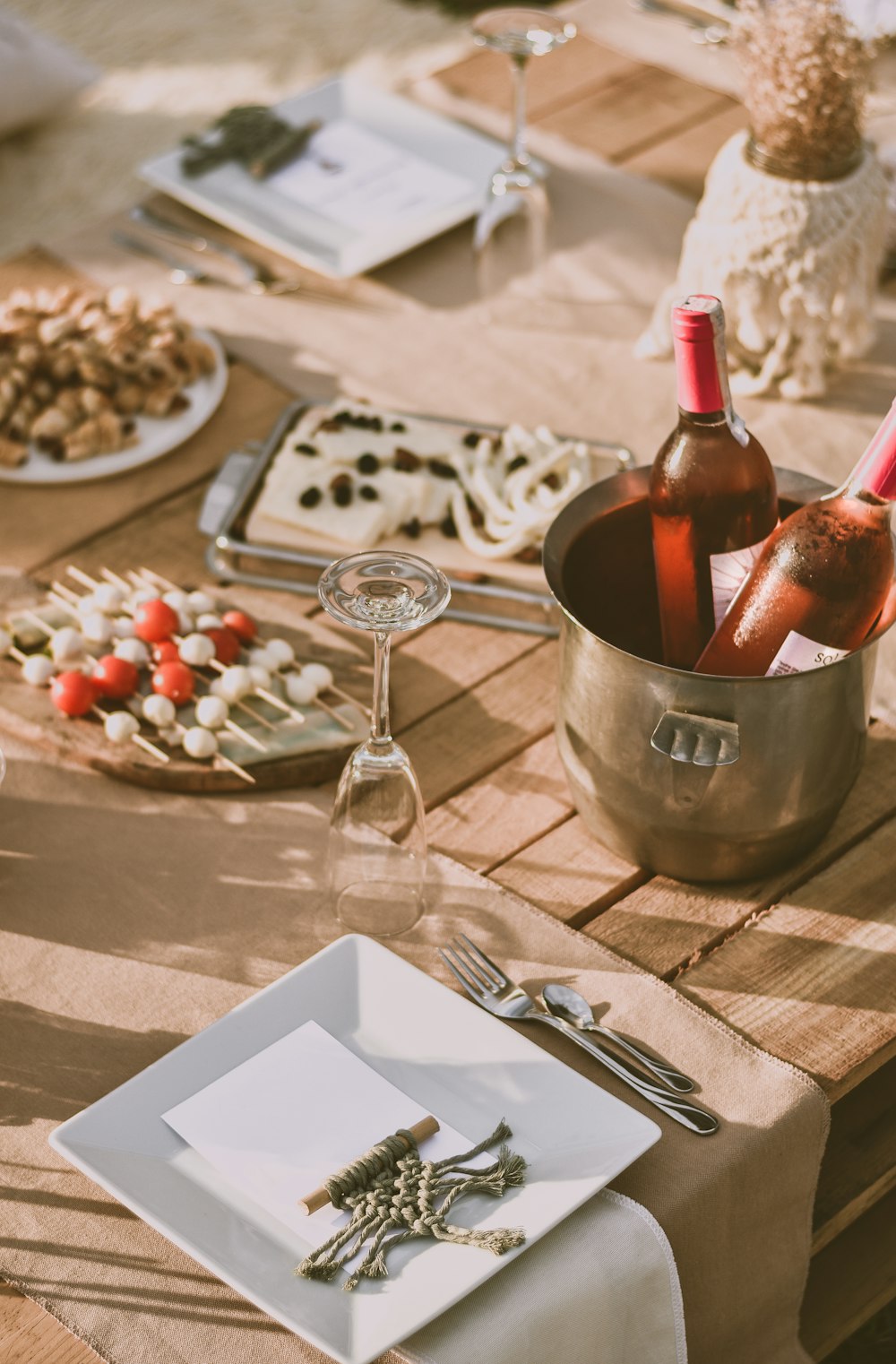 wine bottle on stainless steel bucket beside wine glass on table