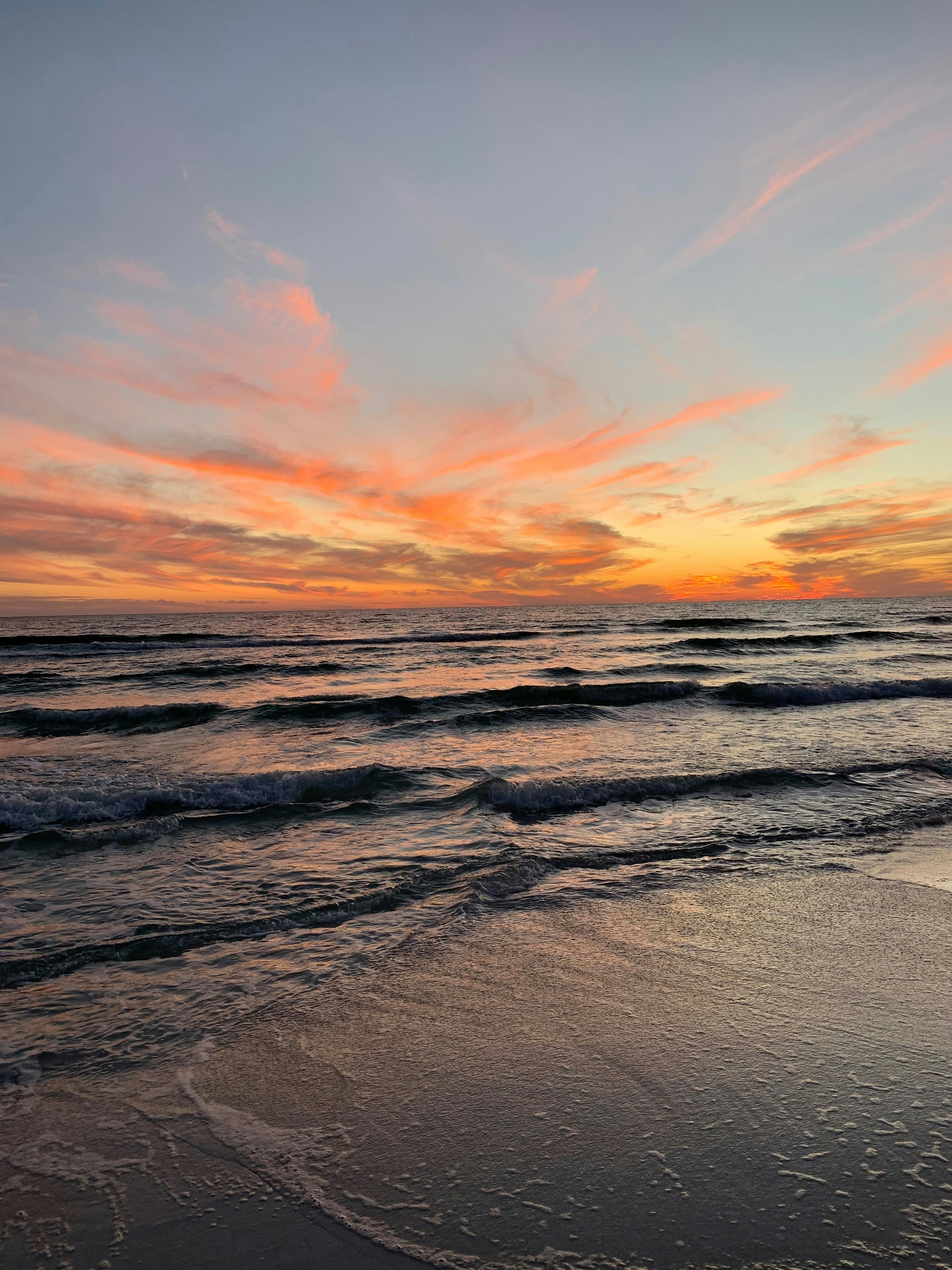 body of water under orange and blue sky during sunset
