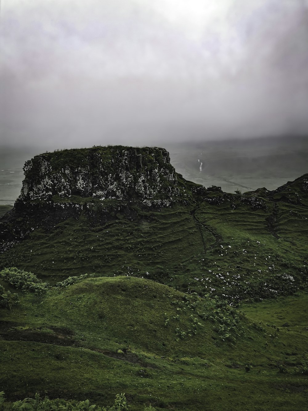 green grass covered mountain under cloudy sky during daytime