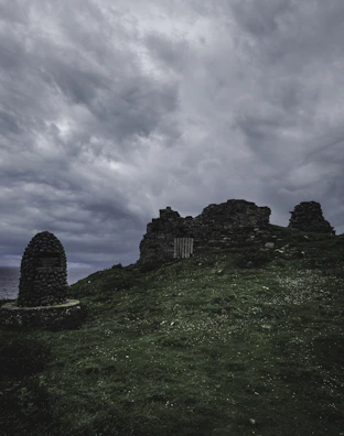 A panoramic view of an ancient stone site under a dramatic cloudy sky.