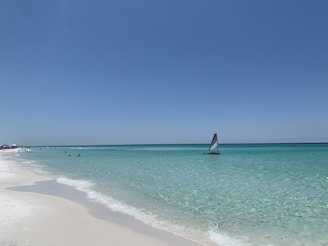 sailboat on sea under blue sky during daytime