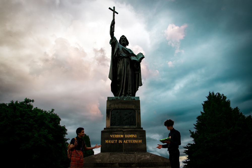 Personas de pie cerca de la Estatua de la Libertad bajo el cielo nublado durante el día