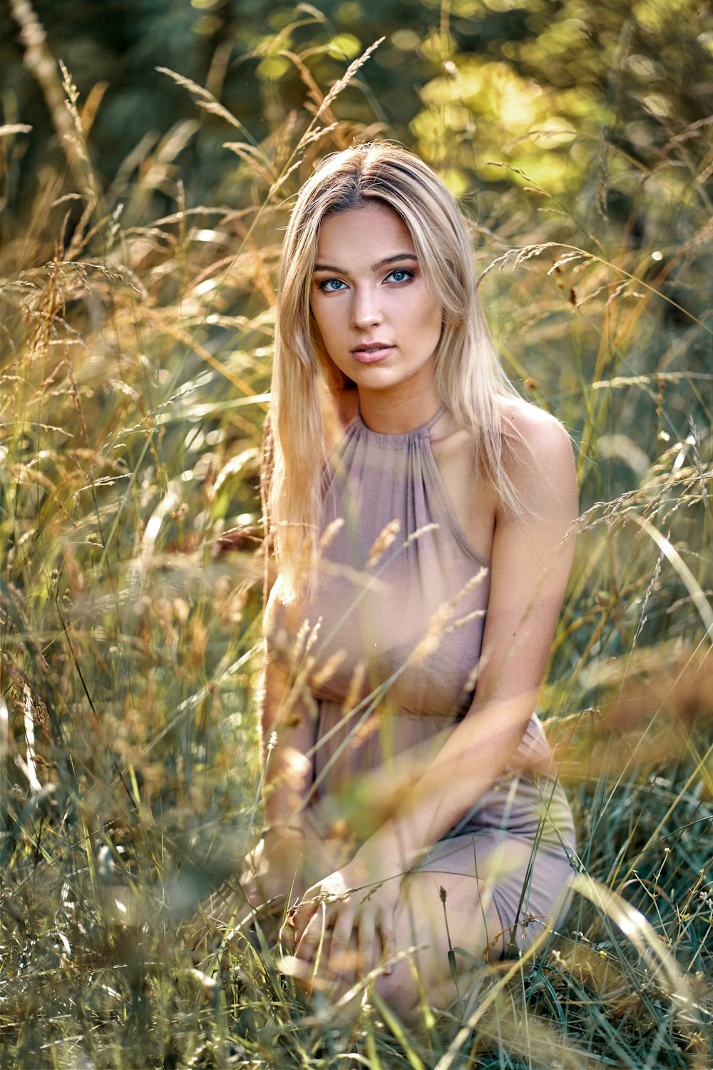 woman in brown tank top standing on green grass field during daytime