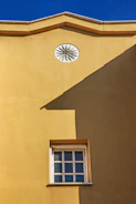 A bright kitchen wall painted in sunny yellow with neat edges and clean finish.