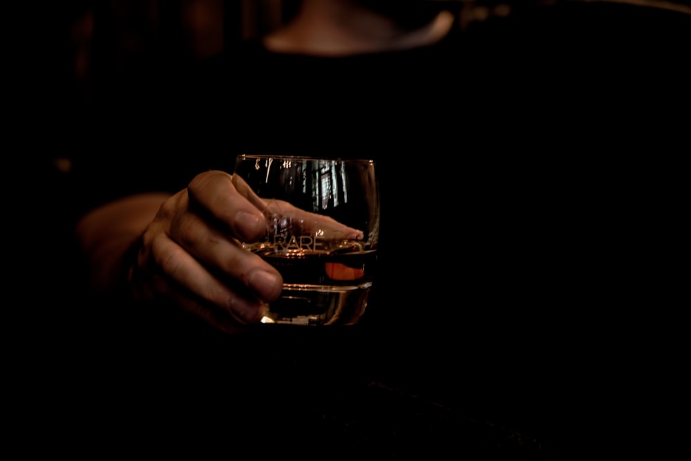 person holding clear drinking glass