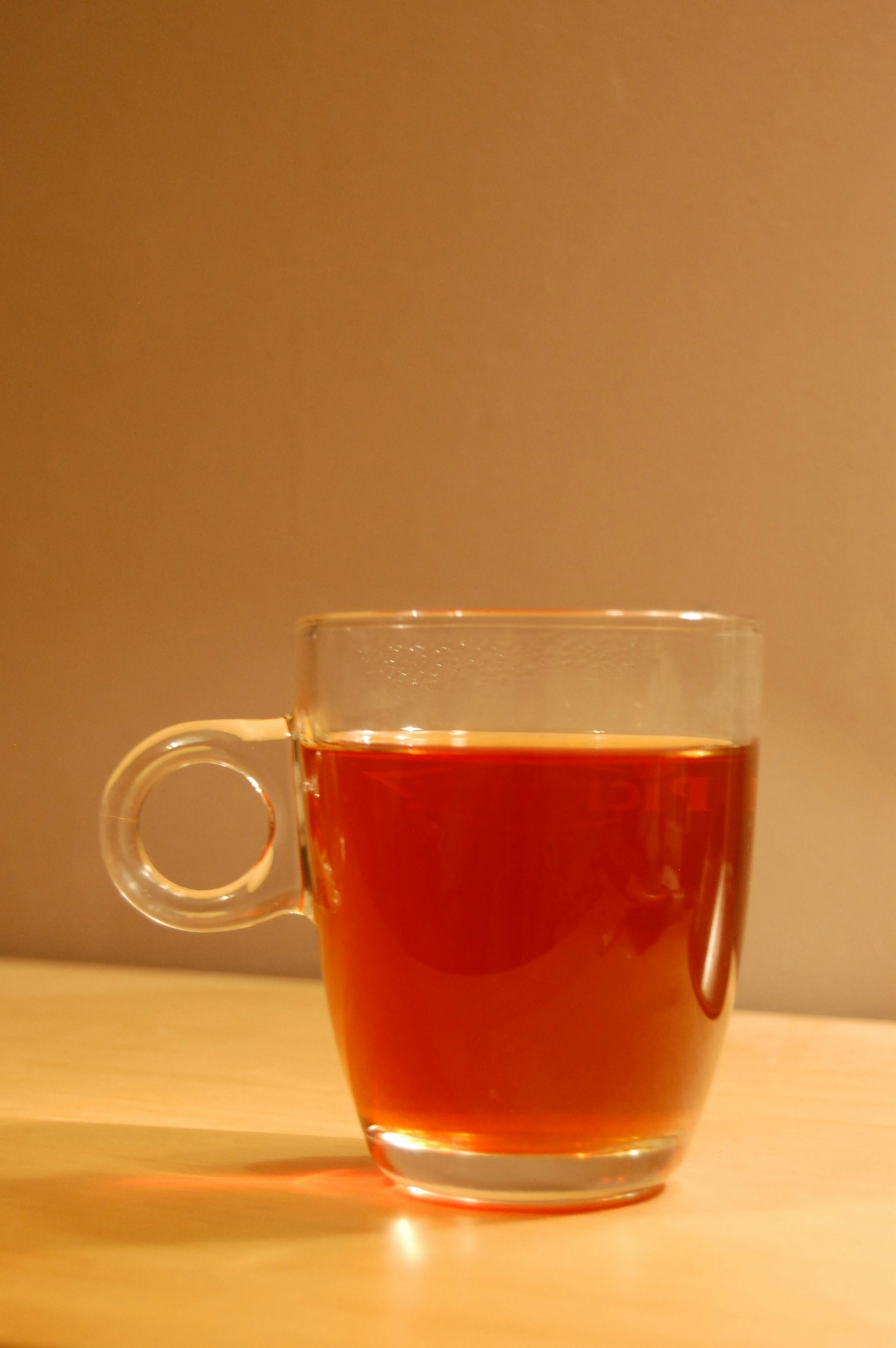 Hygge picture of a glass cup of red tea in a warm homely setting.