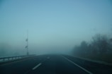Foggy highway with weather-adapt sensors visible along the roadside