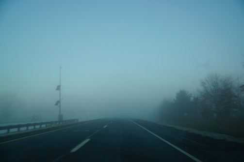 Foggy highway scene with sensors capturing visibility data.