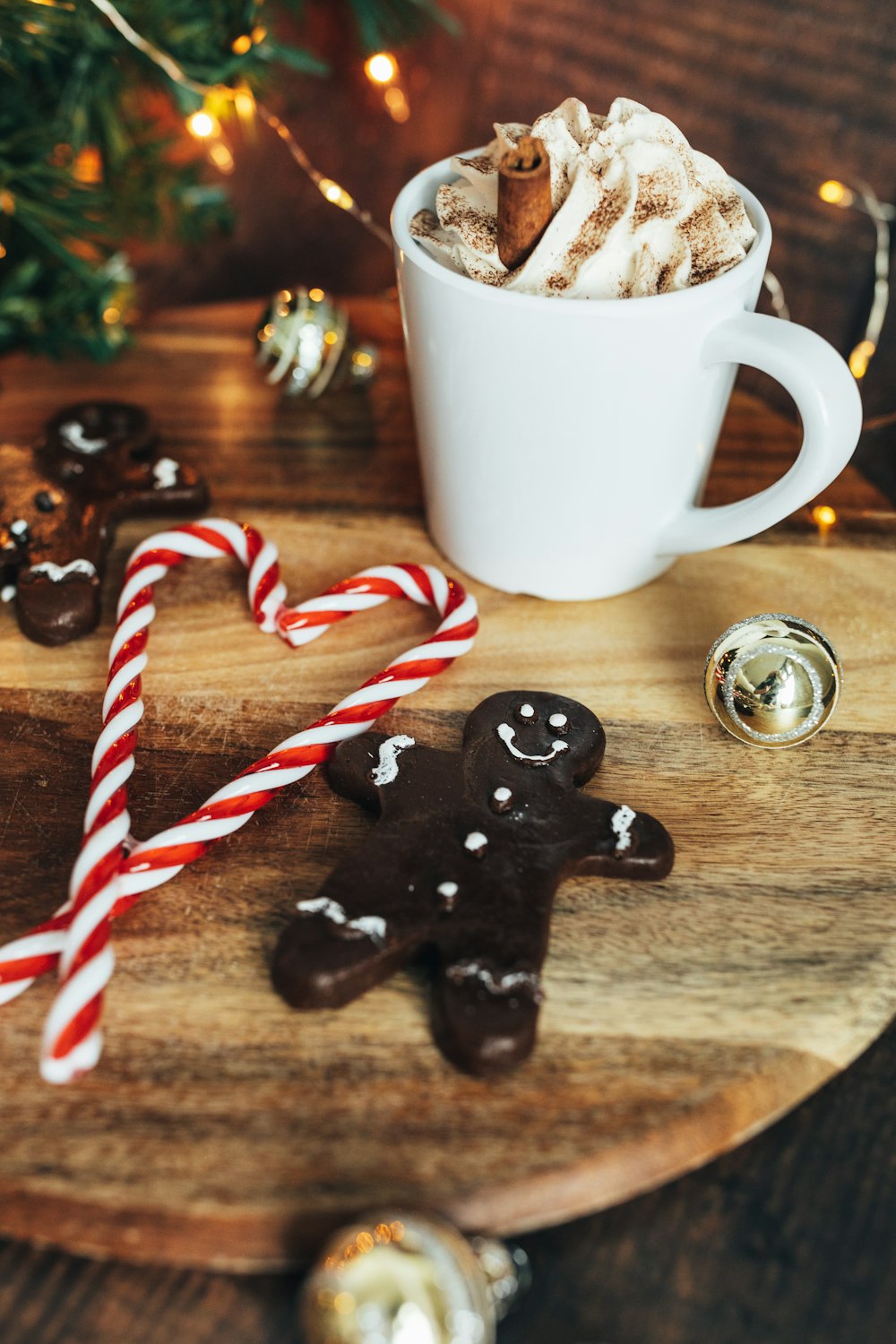 white ceramic mug with coffee beside red and white candy cane