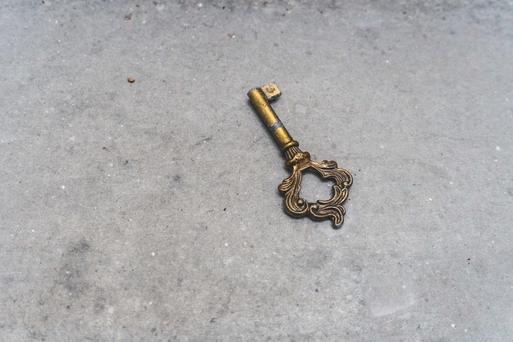 gold skeleton key on gray concrete floor