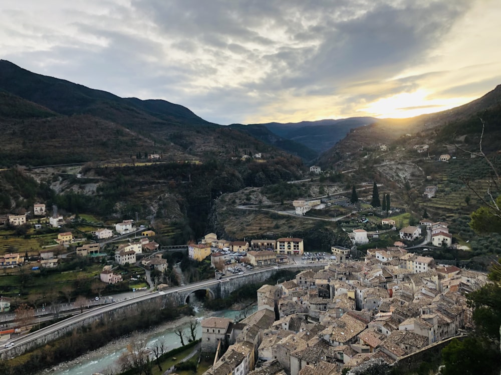 Edifici della città vicino alla montagna sotto il cielo nuvoloso durante il giorno