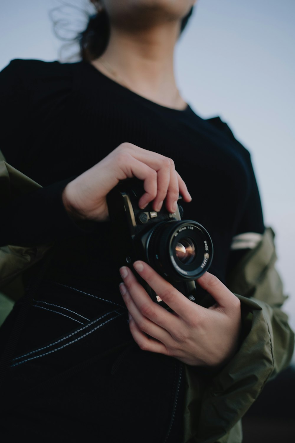 person in black shirt holding black camera