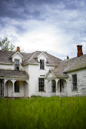 white and gray house under white clouds during daytime