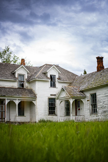 white and gray house under white clouds during daytime