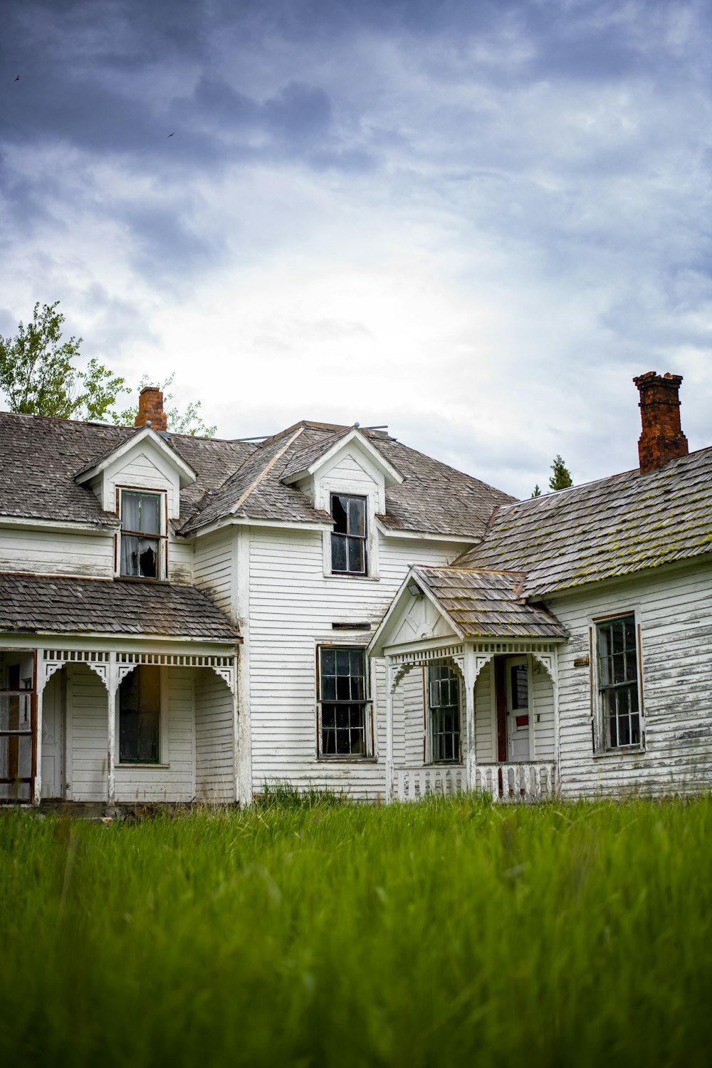 maison blanche et grise sous les nuages blancs pendant la journée