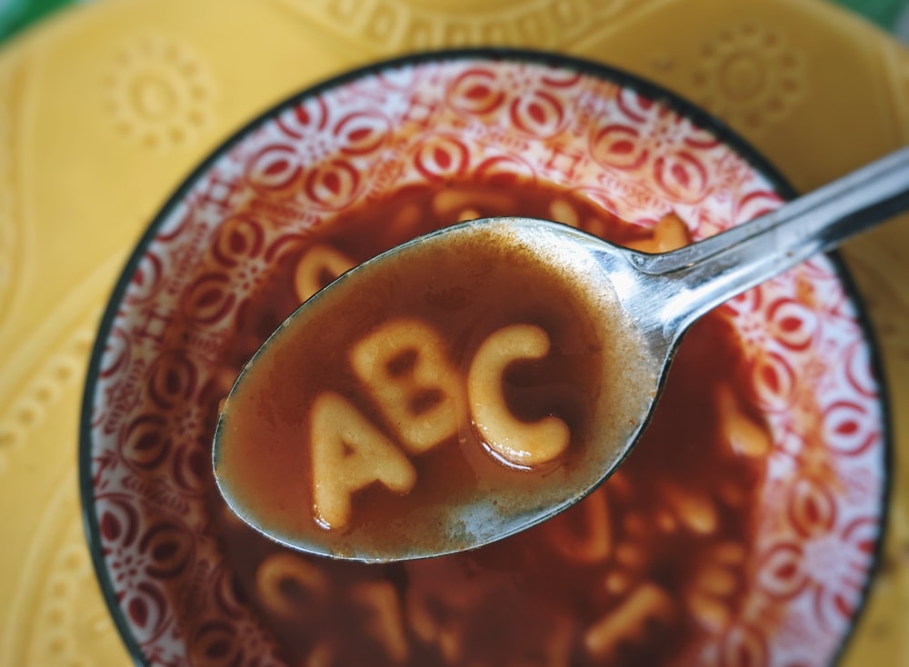 Cuenco de cerámica roja y blanca con cuchara plateada