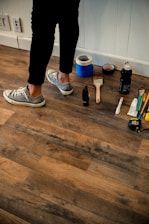 person in black pants and white and black nike renovating home