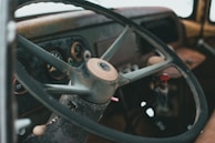 A close-up of a vintage RV dashboard with maps and travel gear scattered around.