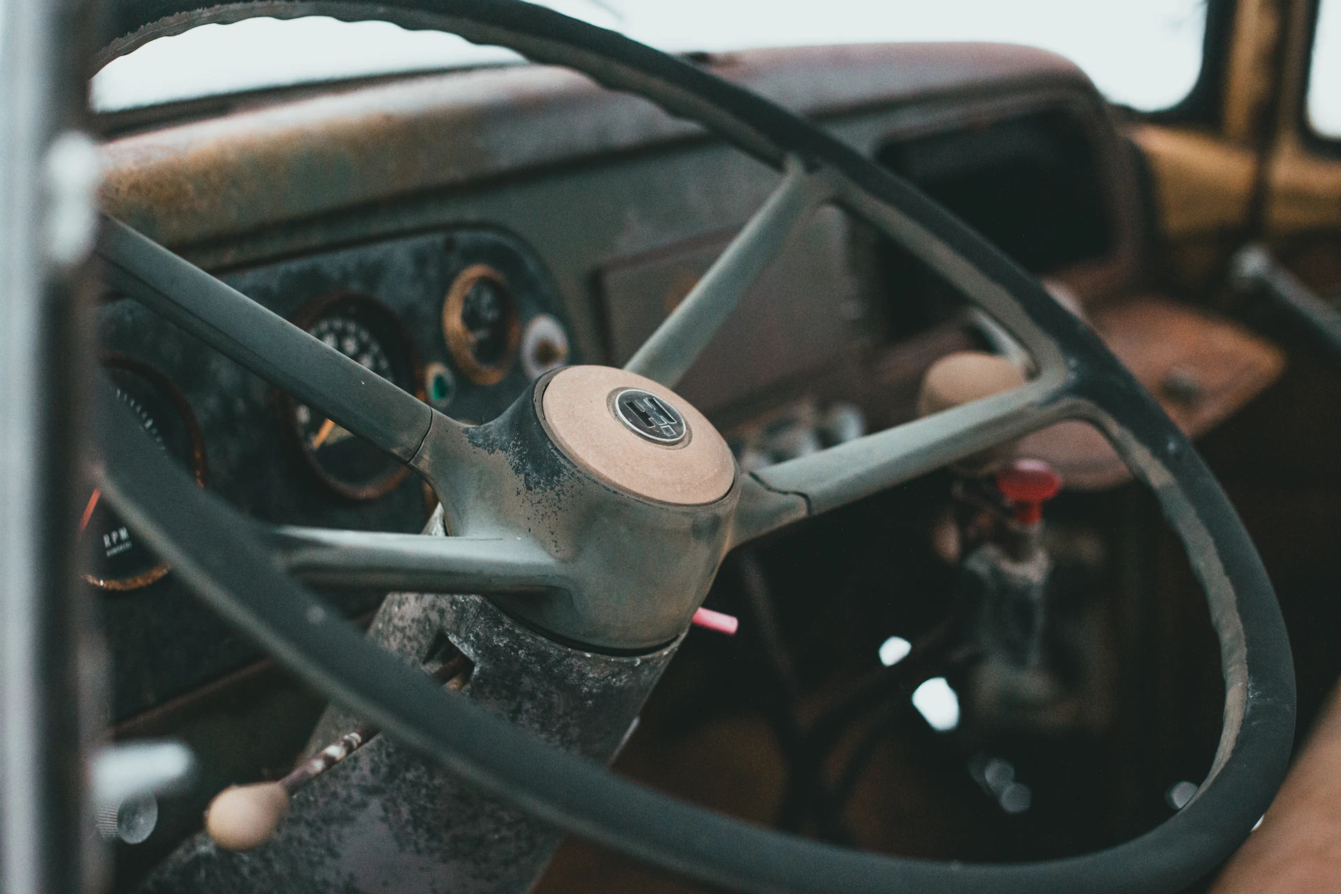 A close-up shot of a weathered vintage car dashboard with rich patina and rustic metal details glowing softly under warm light.