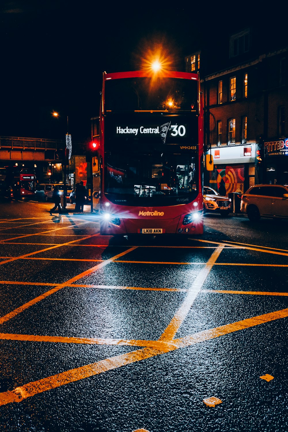 Bus à impériale rouge et noir sur la route pendant la nuit