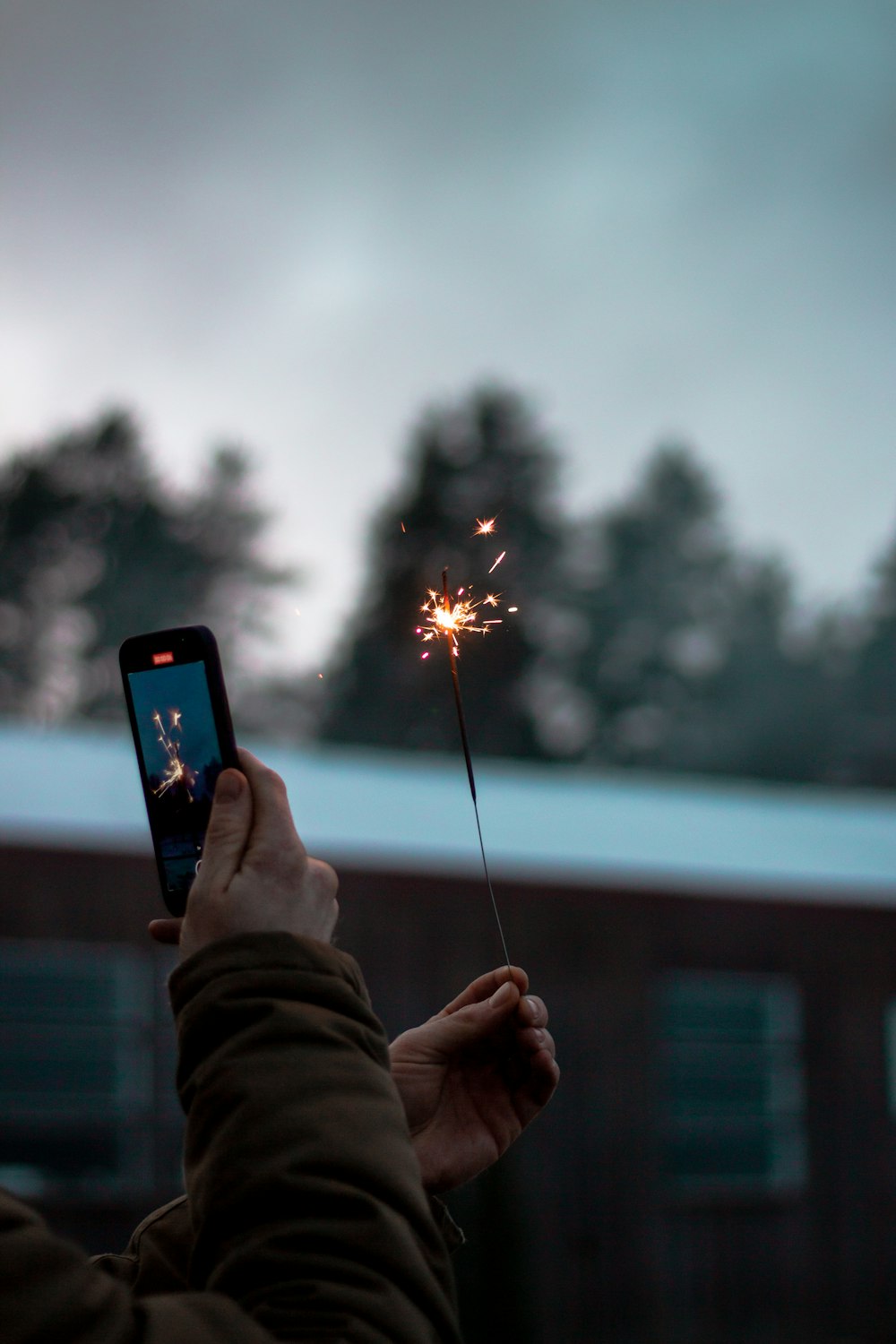 person holding black smartphone taking photo of fire